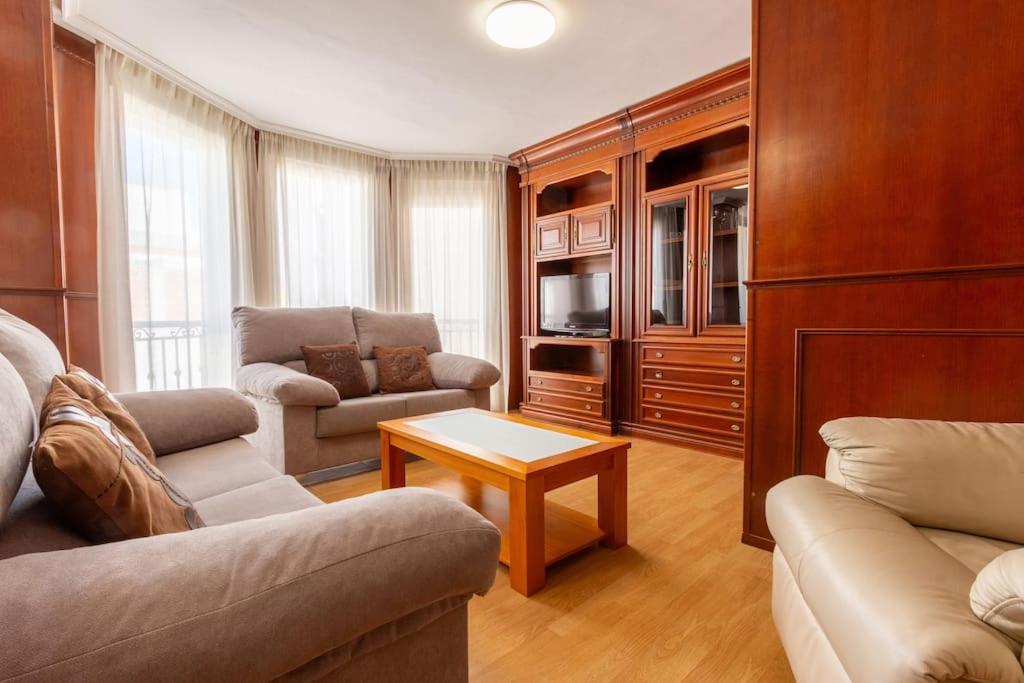 ein Wohnzimmer mit einem Sofa und einem Tisch in der Unterkunft Apartamento Ático Duplex Santa Pola in Santa Pola