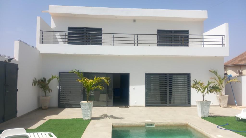 une maison blanche avec une piscine en face de celle-ci dans l'établissement villa de standing, à Sali Nianiaral