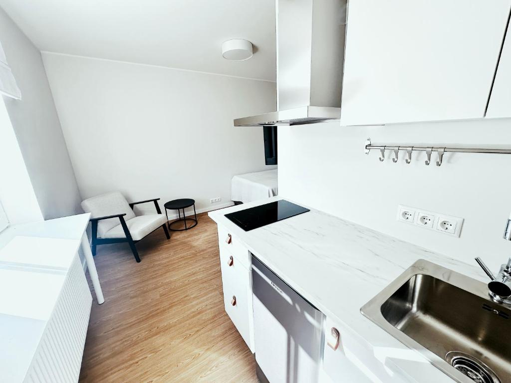 una cocina con armarios blancos y fregadero en VILMSI 52 APARTMENTS, en Tallin