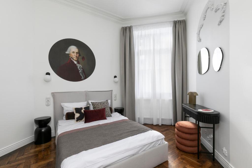 a bedroom with a bed with a portrait of a man at Retro Apartamenty in Przemyśl