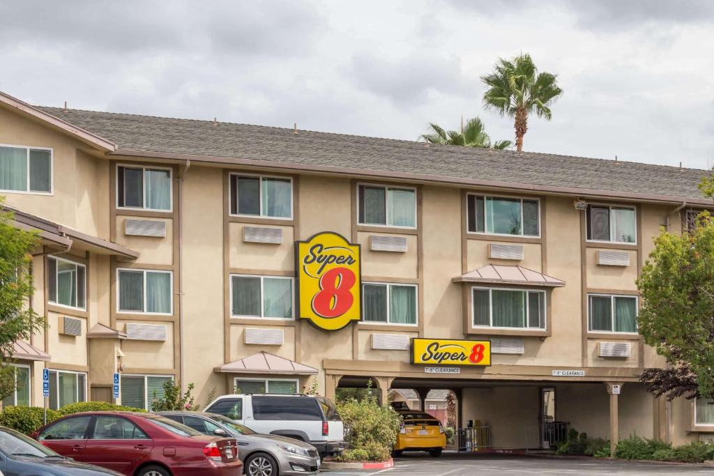 a hotel with cars parked in front of it at Super 8 by Wyndham Sacramento in Sacramento