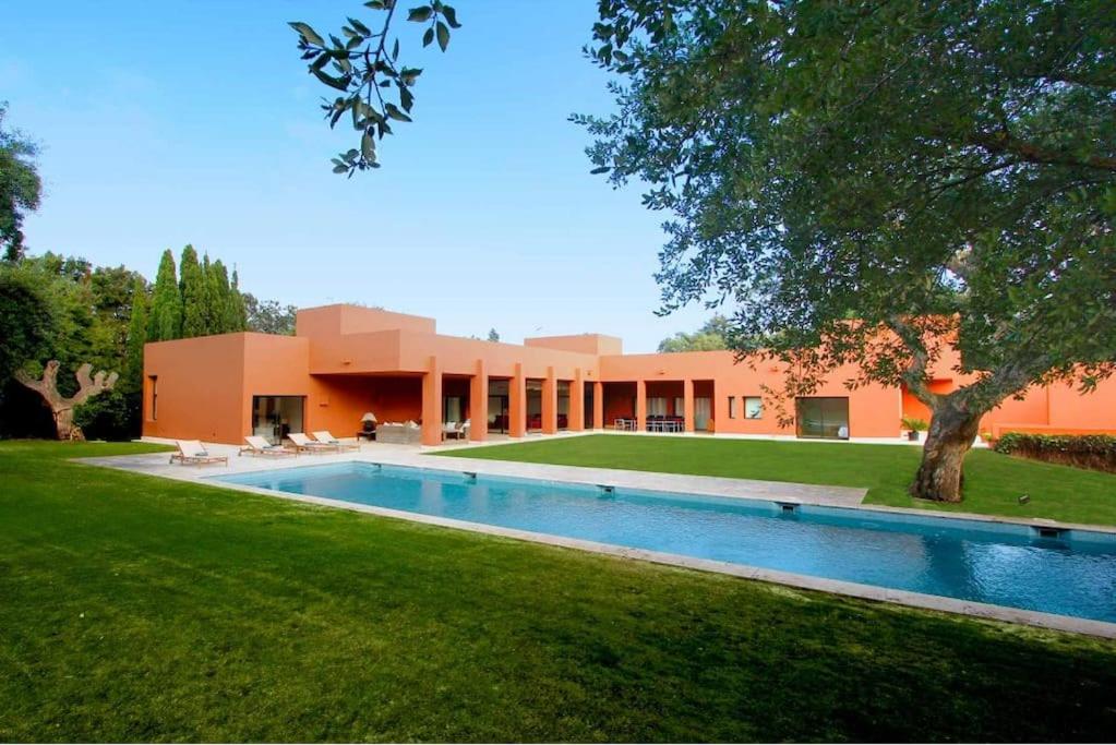 una casa con piscina frente a ella en Chalet moderno en Sotogrande costa, en San Roque