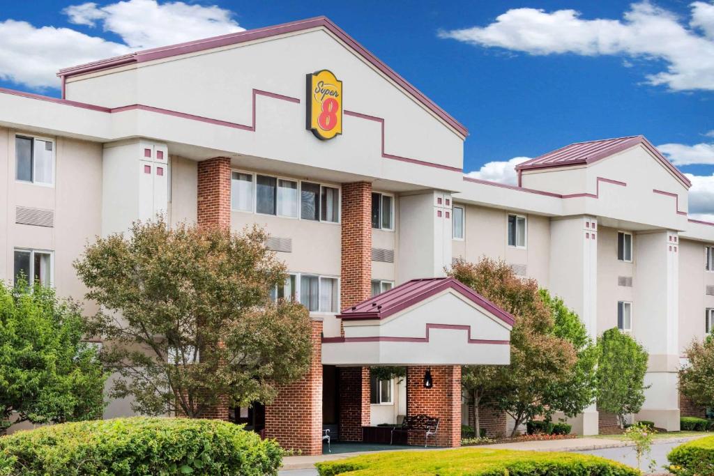 een hotelgebouw met een krispy kreme-bord bij Super 8 by Wyndham State College in State College