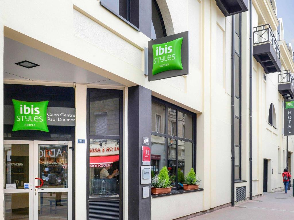 una tienda con letreros al lado de un edificio en ibis Styles Caen Centre Historique, en Caen