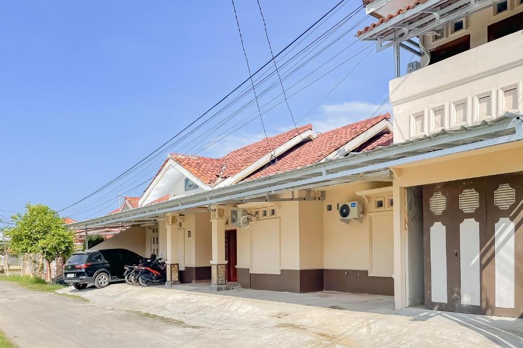 un coche aparcado frente a una casa en Urbanview Hotel Sany Cirebon en Tangkil
