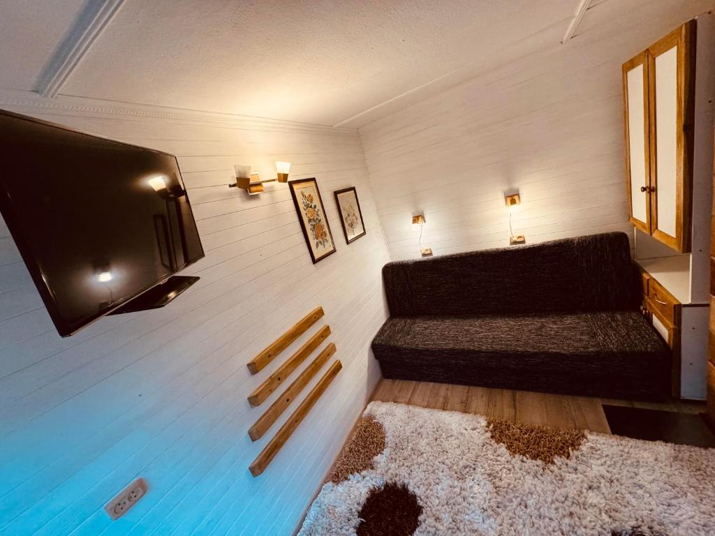 Zimmer mit Sofa und Flachbild-TV in der Unterkunft LauvasNams in Dubeņi