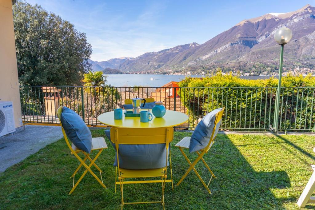 a yellow table and chairs with a view of the water at Lunas Apartment by Wonderful Italy in Bellagio
