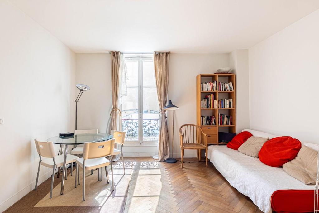 a living room with a bed and a table and chairs at GuestReady - Sunlit Serenity near Montmartre in Paris