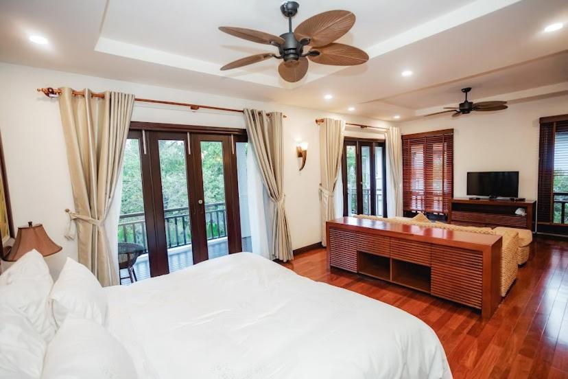 a bedroom with a bed and a couch and a television at Villa Đà Nẵng Gần Biển - Biệt Thự Đà Nẵng in Da Nang