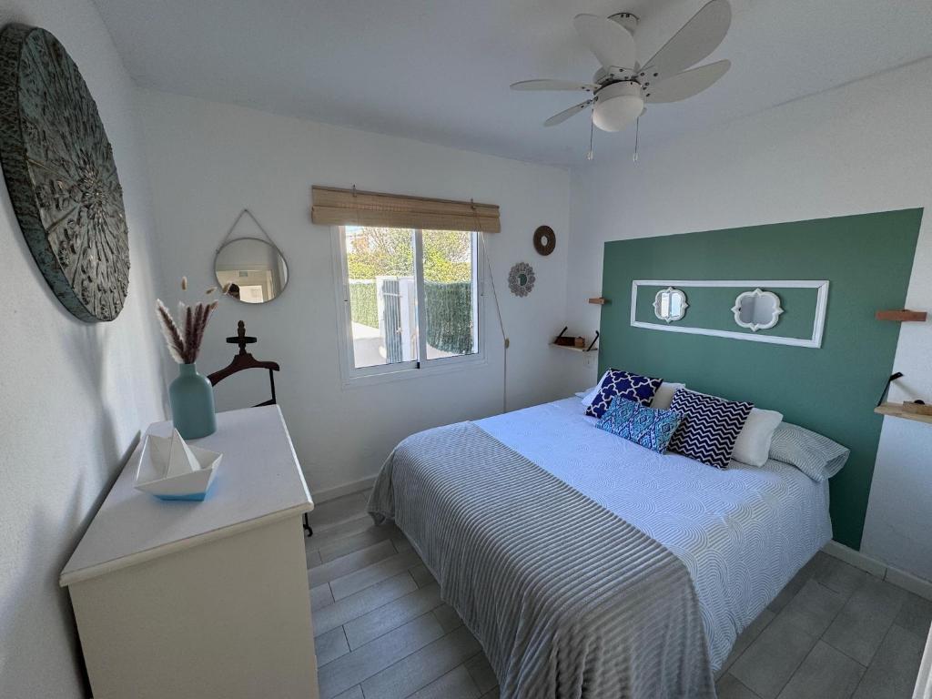 een kleine slaapkamer met een bed en een raam bij Apartamento en Cala en Porter, Menorca. in Cala'n Porter