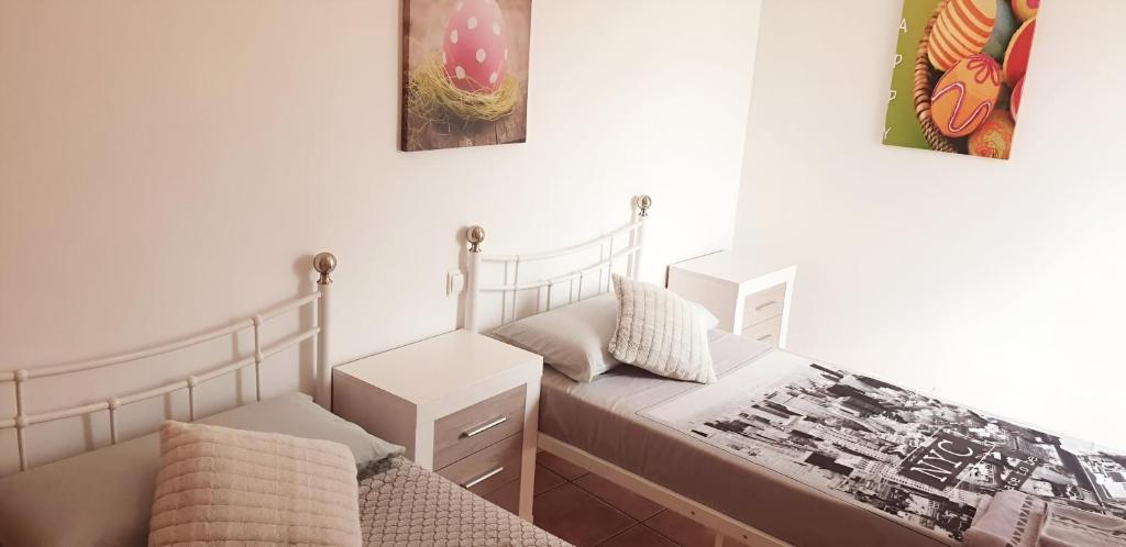 a small bedroom with a bed and a night stand at Flamingo Vila Alicante in San Pedro del Pinatar