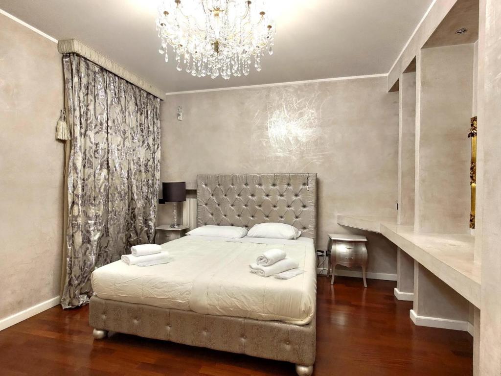 Schlafzimmer mit einem Bett und einem Kronleuchter in der Unterkunft Villa Eleganza Milano Bergamo Airport in Dalmine