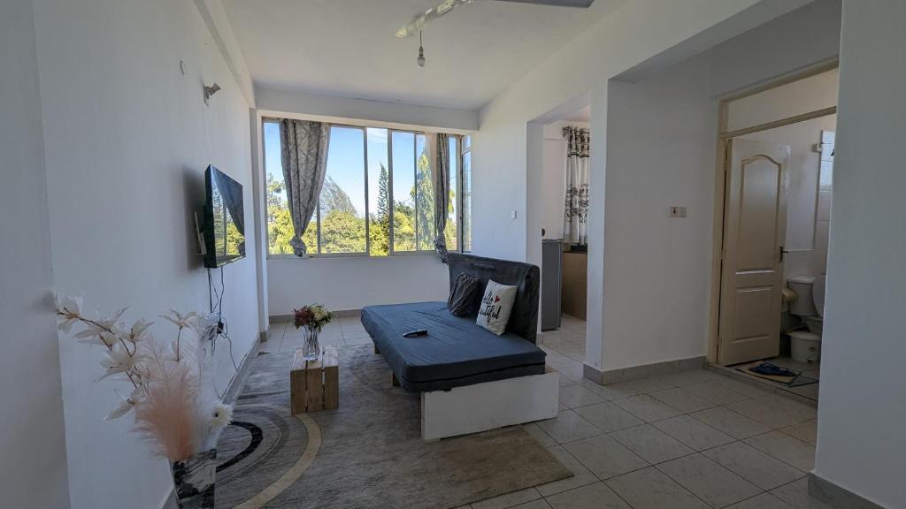 uma sala de estar com um sofá e uma janela em Sea Spray Apartment em Ukunda