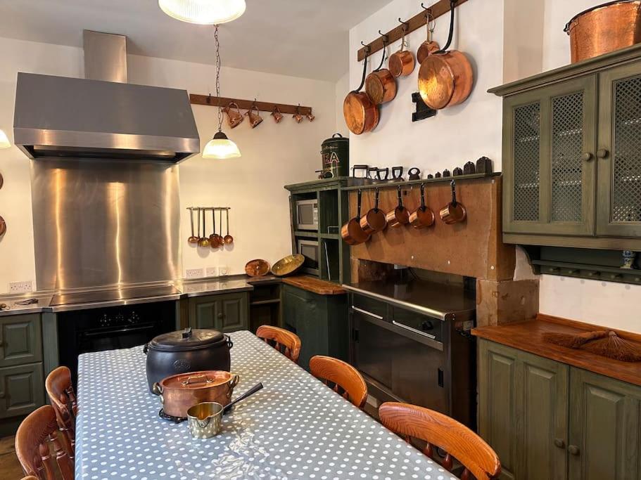 uma grande cozinha com uma mesa com uma mesa; em Victorian Copper Cottage em Lancaster