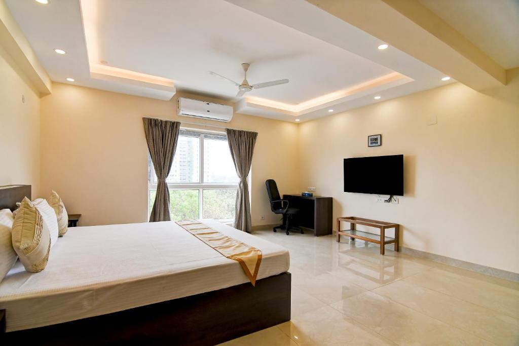 a bedroom with a bed and a flat screen tv at AVS Prime in kolkata