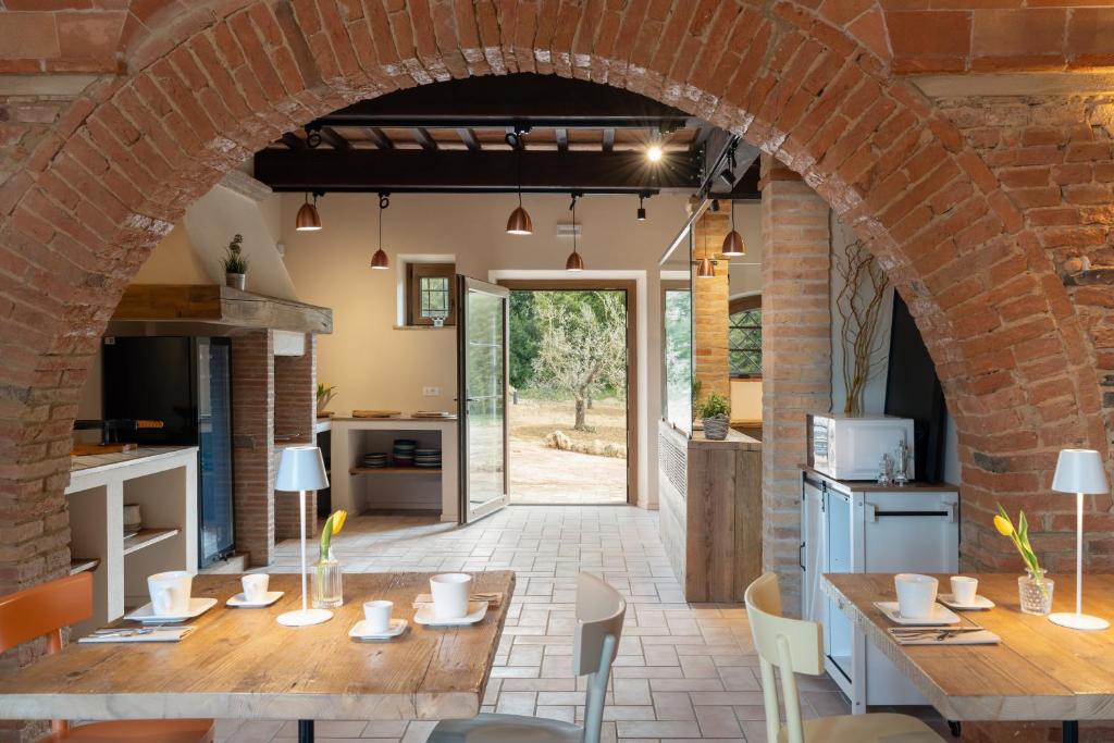 an open kitchen and dining room with a brick archway at Tenuta i 4 venti in Collesalvetti