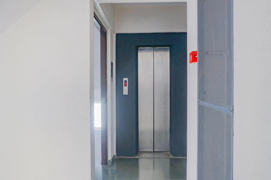 a corridor with a door in a room with blue walls at OYO Flagship I- Siri Lodge in Pune