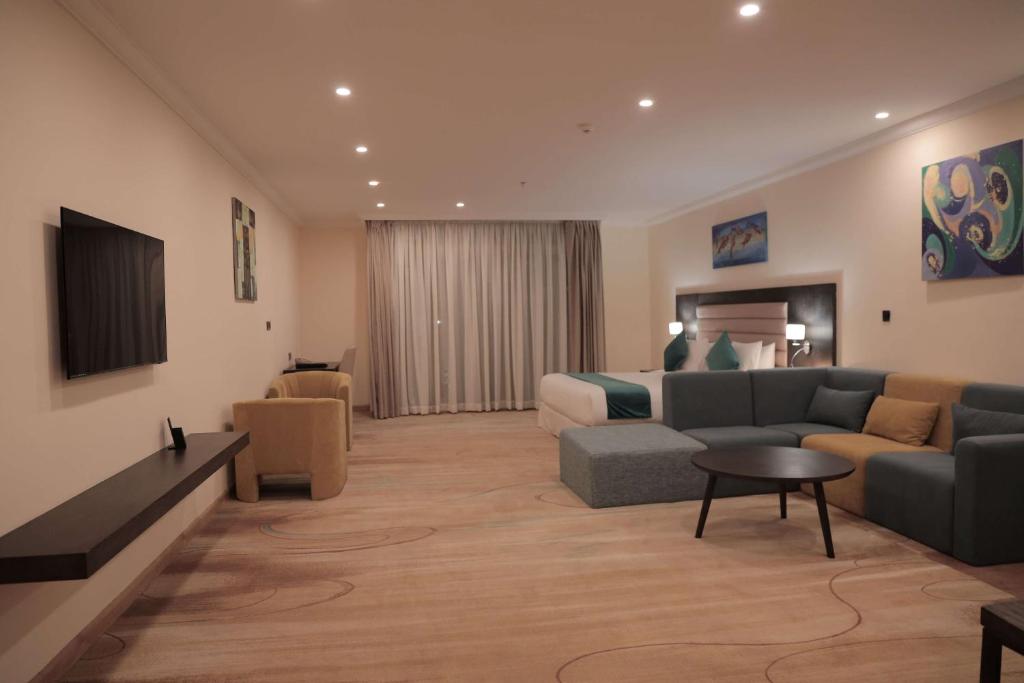 uma grande sala de estar com um sofá e uma cama em Best Western Premier Dynasty em Addis Ababa