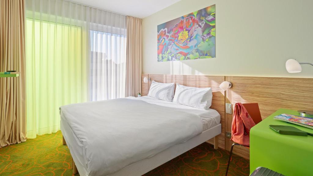 希爾德斯海姆的住宿－Hey Lou Hotel Hildesheim，卧室配有白色的床和绿色书桌