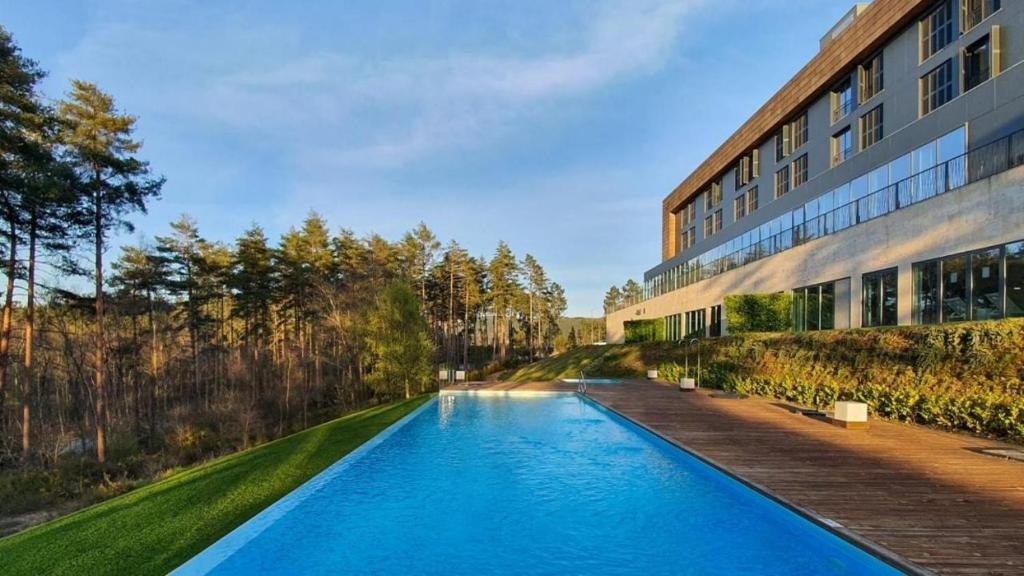 a swimming pool in front of a building at Pena Park Hotel in Ribeira de Pena