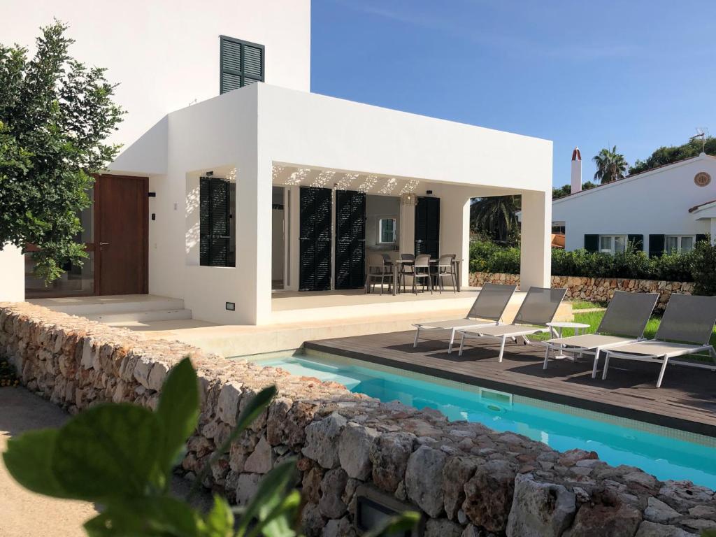 a villa with a swimming pool and a house at Nure Villas Mar y Mar in Cala en Blanes