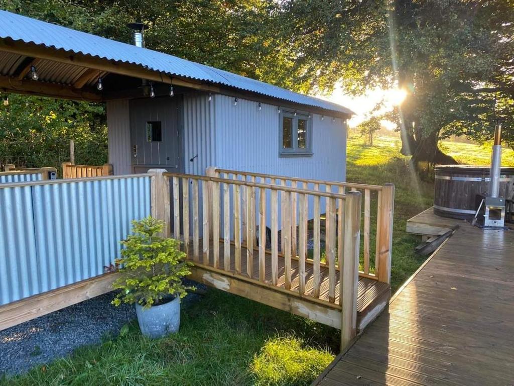 Casa pequeña con porche de madera y terraza en Hawkings Hideaway, en Knowstone
