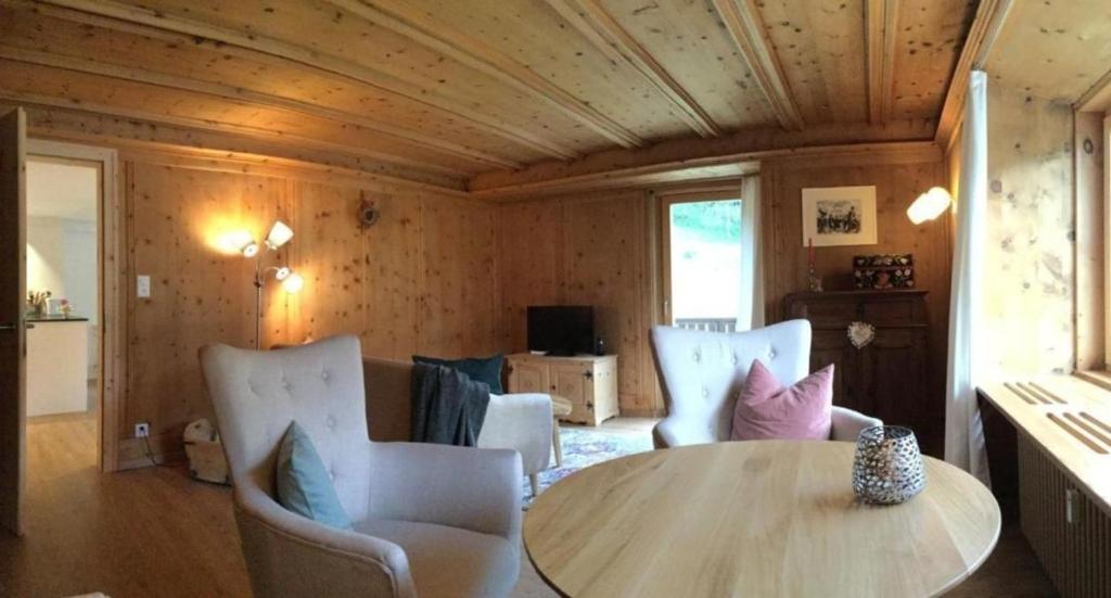 Zimmer mit Holzdecke, Tisch und Stühlen in der Unterkunft Chesa Kober, Wohnung 4 in Pontresina