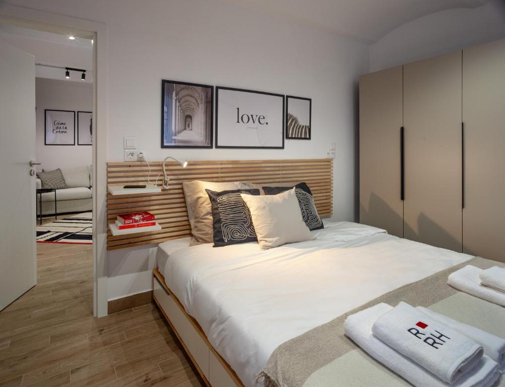 um quarto com uma cama grande e lençóis brancos em Ruby Red House em Sófia