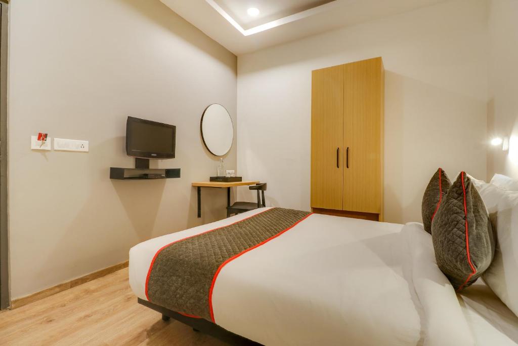 a bedroom with a bed and a television in it at OYO Townhouse 591 Hotel Woodland in Nagpur