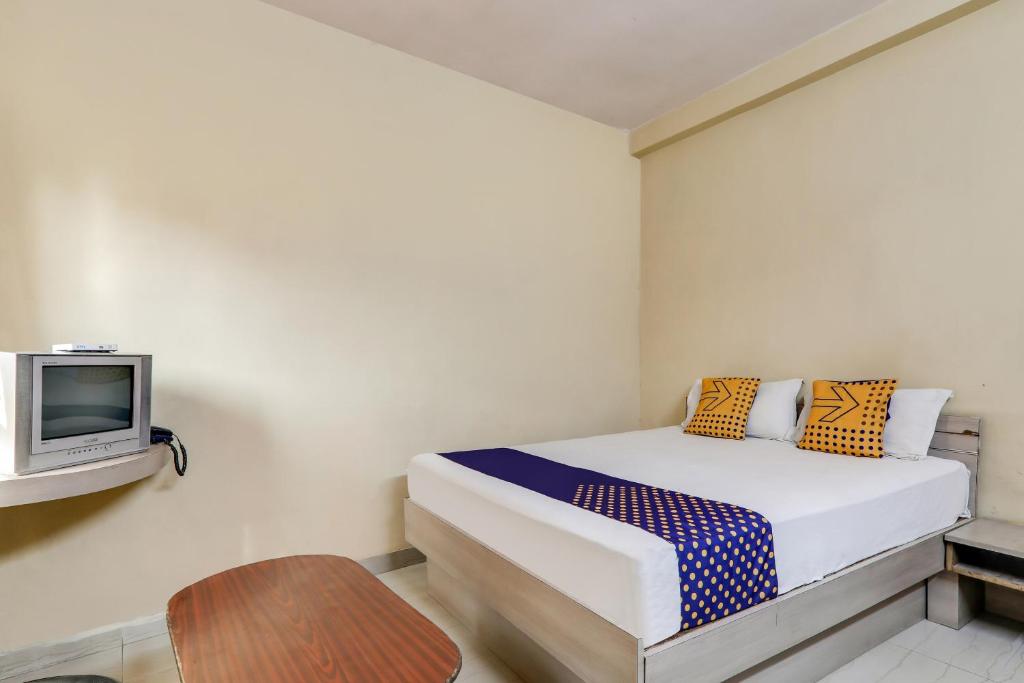 a bedroom with a bed and a tv on a wall at OYO Flagship Horas Regency in Rānchī