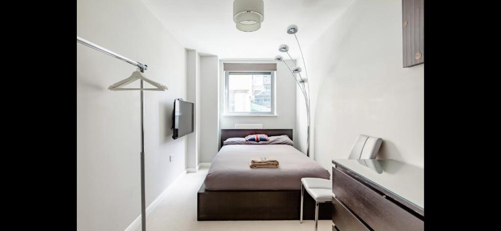 a small bedroom with a bed and a window at Canary Wharf Private Bedroom in London