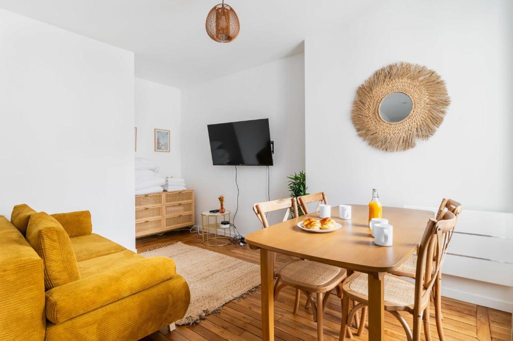 un salon avec une table et un canapé dans l'établissement Jolie 2 pièces proche métro - Paris 19 - 4p - FLAT-GUEST, à Paris