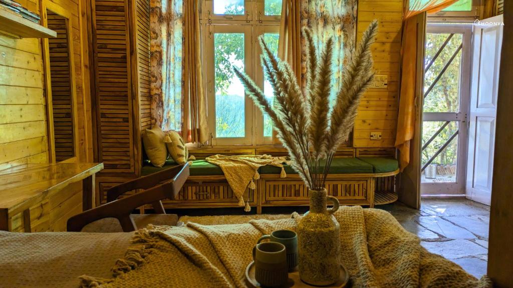 a room with a table in a log cabin at Shoonya Mukteshwar in Mukteswar