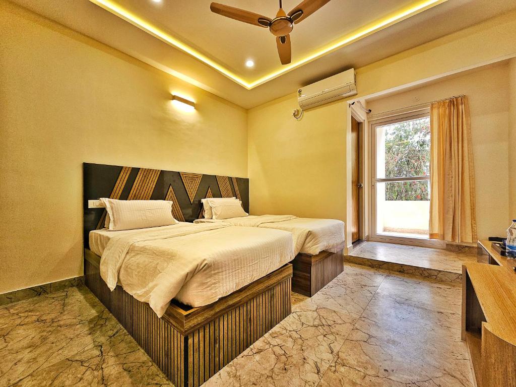een slaapkamer met 2 bedden en een raam bij Hotel Aaryan Comforts - Peenya in Bangalore
