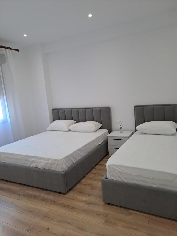 two beds sitting next to each other in a bedroom at Erdis Home Nr 1 in Tirana