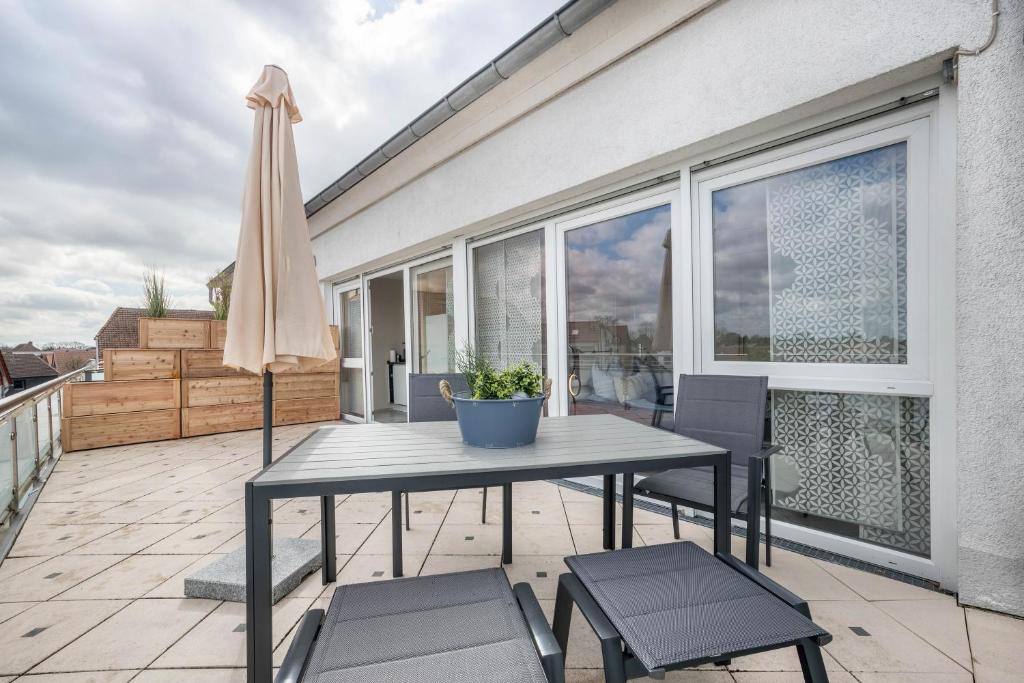 a table and chairs on a balcony with an umbrella at Studio in Steinhude