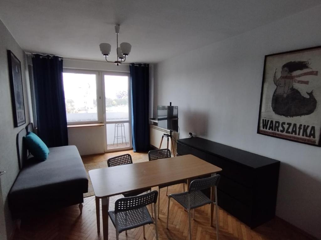 a living room with a table and chairs and a couch at Warszawa Apartament z Widokiem in Warsaw