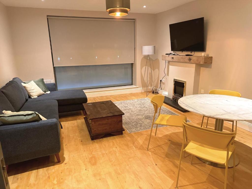 ein Wohnzimmer mit einem Sofa und einem Tisch in der Unterkunft Dallkey Retreat in Dalkey