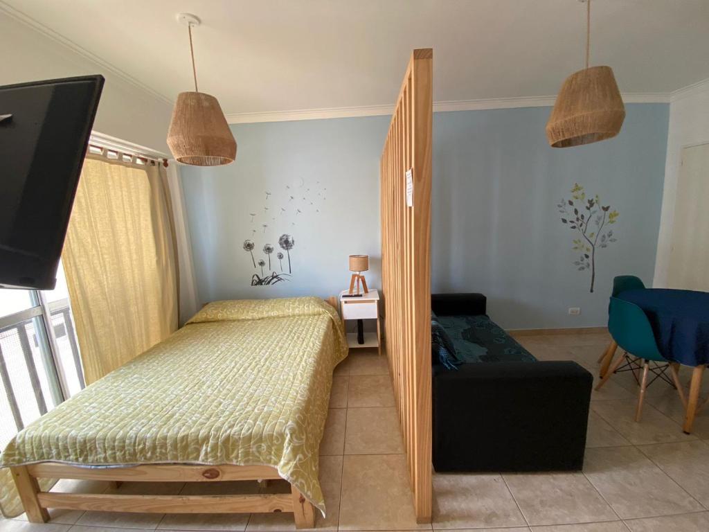 1 dormitorio con cama, sofá y TV en departamento boutique zona aldrey en Mar del Plata