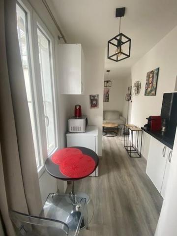une chambre avec un tabouret rouge et une cuisine dans l'établissement Studio cosy Paris Odéon, à Paris