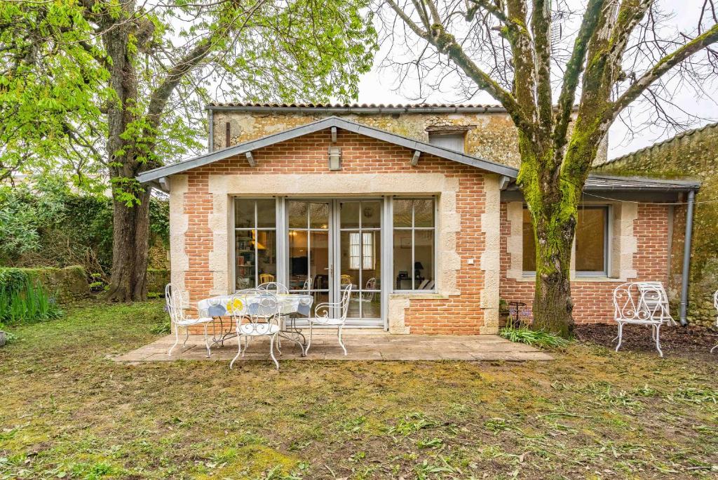 una casa de ladrillo con mesa y sillas en La Maison Télémaque, en Marennes