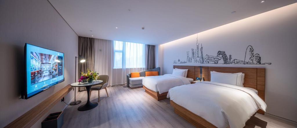 Postel nebo postele na pokoji v ubytování UrCove by HYATT Shanghai Jing'An