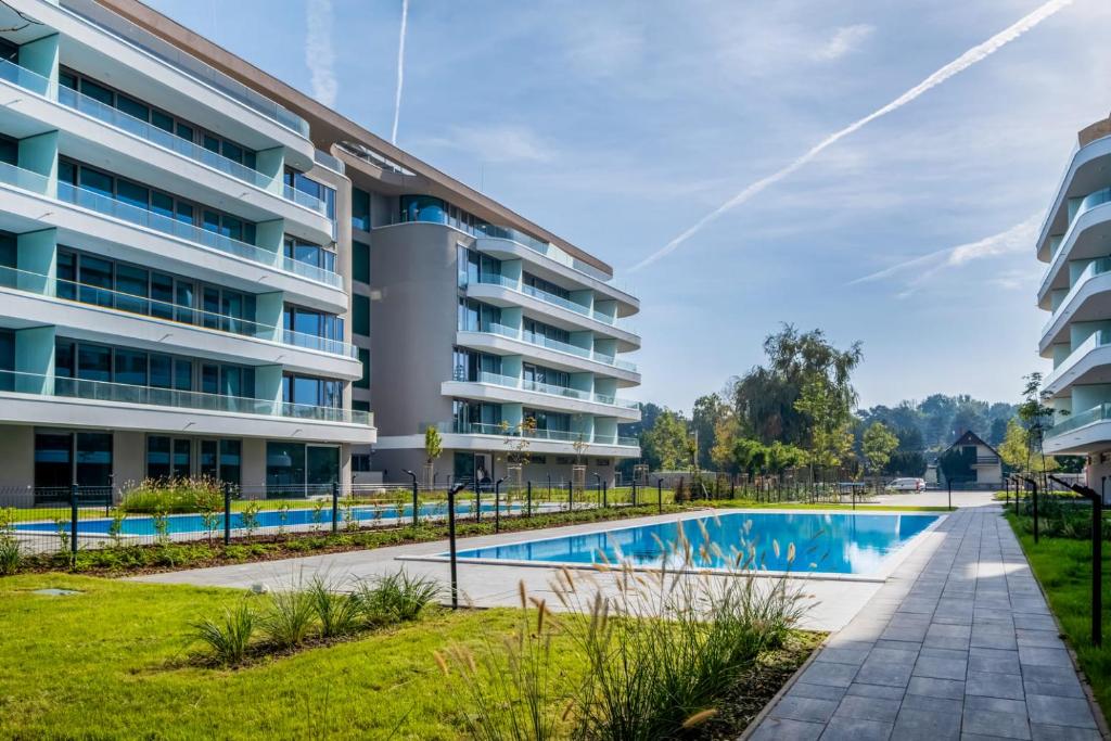 une image d'un immeuble d'appartements avec une piscine dans l'établissement MF Wave Botanic Apartment, à Siófok