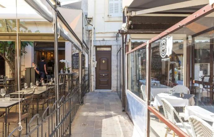 - un restaurant avec des tables, des chaises et une porte dans l'établissement Appartement authentique situé en plein centre d'Antibes, à Antibes