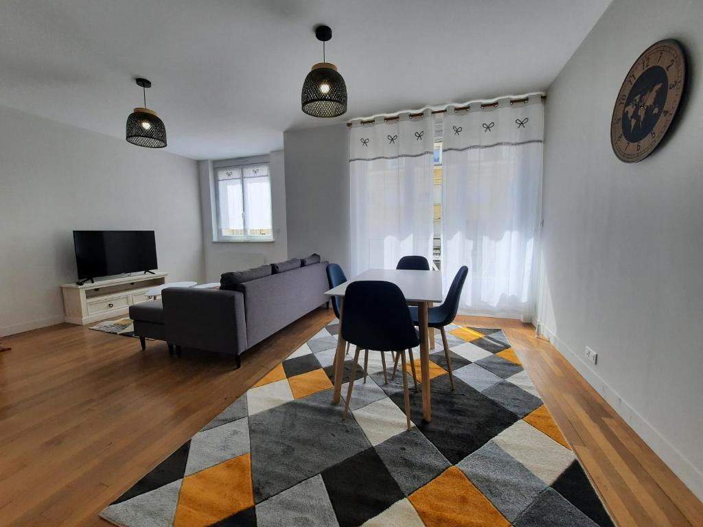 ein Wohnzimmer mit einem Tisch und einem Sofa in der Unterkunft Appartement cœur de ville in Beauvais