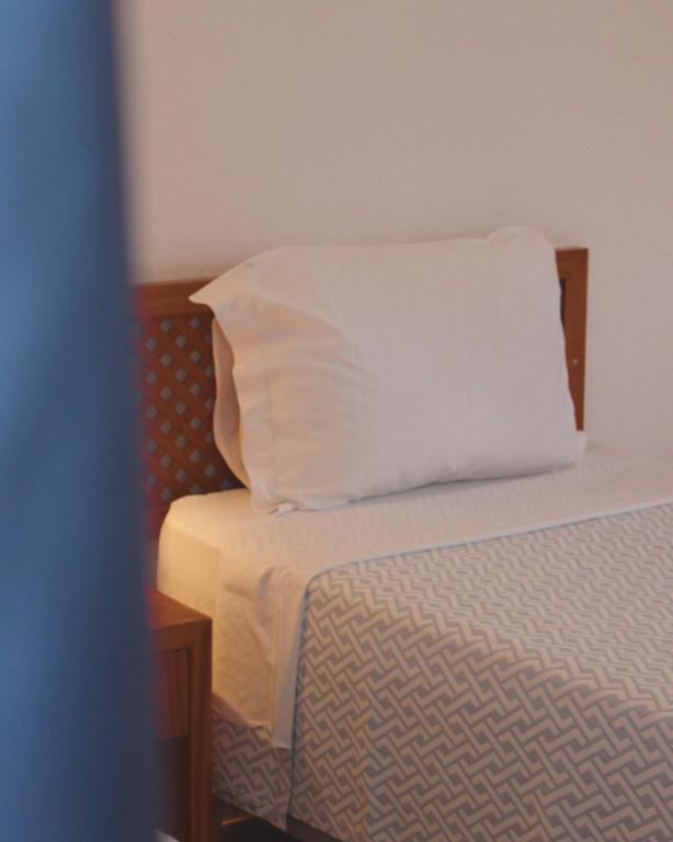 a white pillow sitting on top of a bed at Vegas Residence in Albufeira