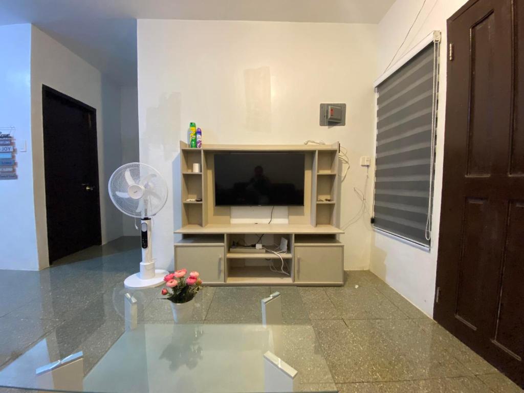 a living room with a television and a fan at Radex Place Staycation , 2BR, 6 PAX in Mati