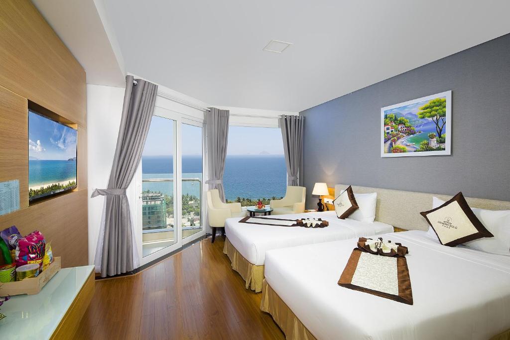 a hotel room with two beds with a view of the ocean at Dendro Gold Hotel in Nha Trang