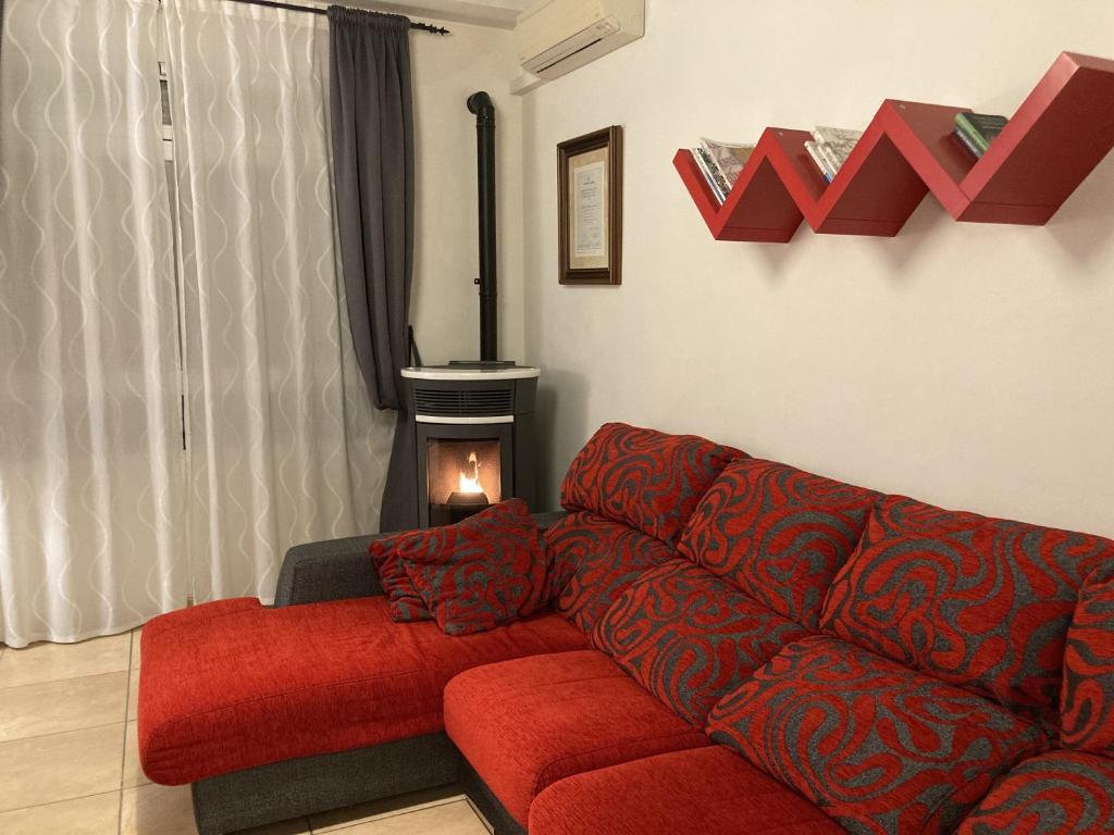 sala de estar con sofá rojo y chimenea en Ático duplex de Maria Jesús, en Buñol