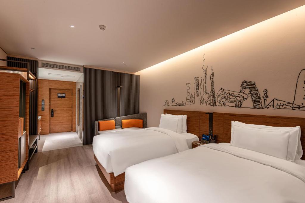 Postel nebo postele na pokoji v ubytování UrCove by HYATT Shanghai Jing'An